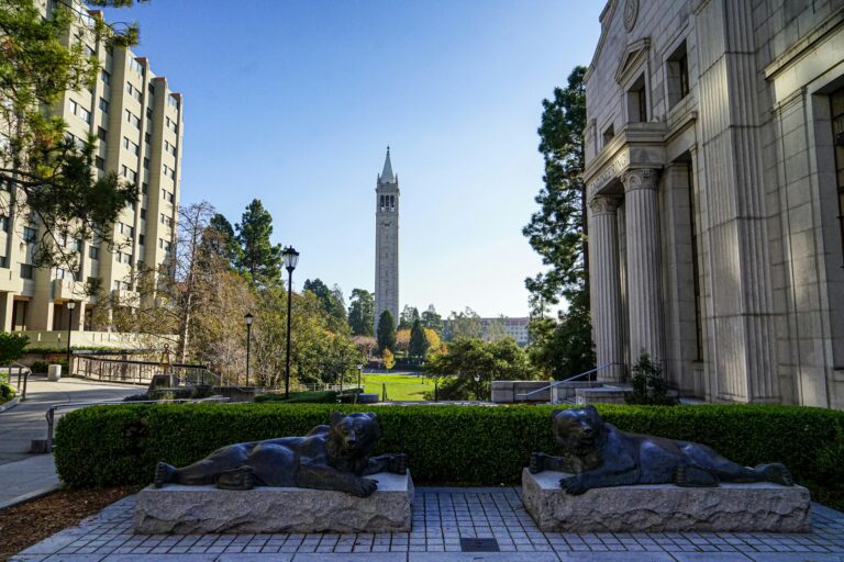 UC Berkeley campus view with Sather Tower in the background and lion statues in the foreground