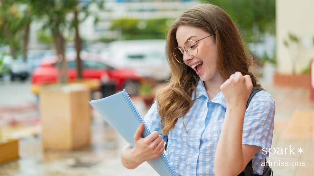 Young redhead student woman at outdoors celebrating a victory